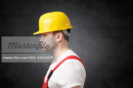 Side view of a sad construction worker with yellow hard hat