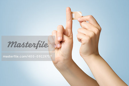 Woman putting a plaster on her index finger