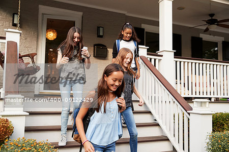 Four teen girlfriends leaving house for school