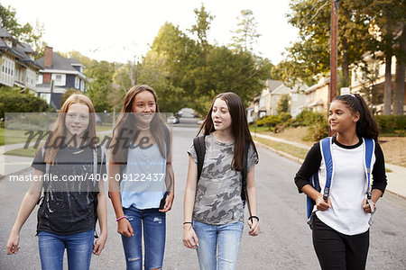 Four young teen girls walking in the road, close up