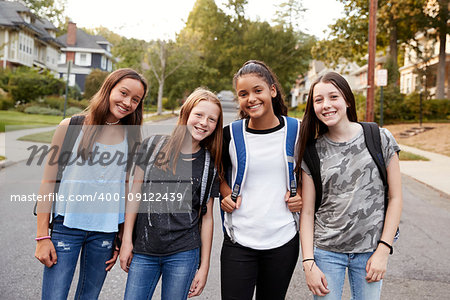 Teen girls on the way to school looking to camera, close up