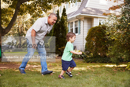 Grandfather Playing In Garden With Grandson