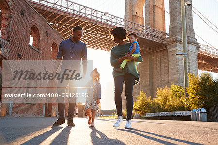 Young family with two daughters walk on a street