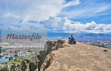 Mother and sons beside quad bike, on mountain top, La Paz, Bolivia, South America