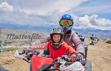 Mother and son on top of mountain, using quad bike, La Paz, Bolivia, South America