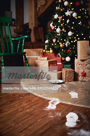 Christmas tree surrounded by presents, Santa's footprints leading towards tree