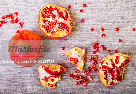 Pomegranate pieces and seeds on table