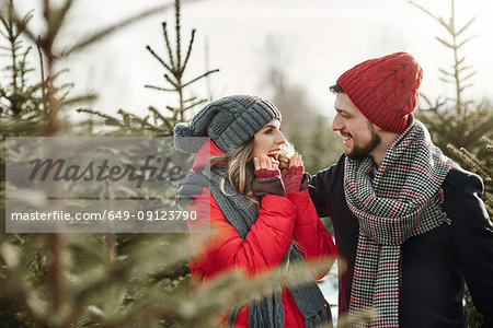 Happy young couple in christmas tree forest