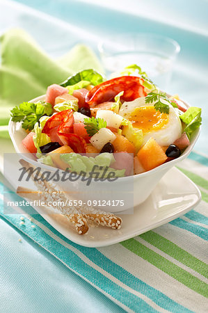 Salad with salami, half an egg, melon and olives