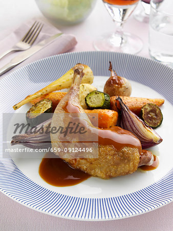 A roast leg and thigh of guinea fowl and vegetables