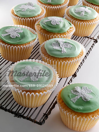 Cupcakes with a white shamrock on top of the green icing