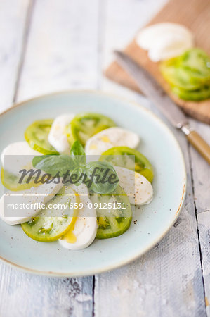 Caprese with green tomatoes and basil