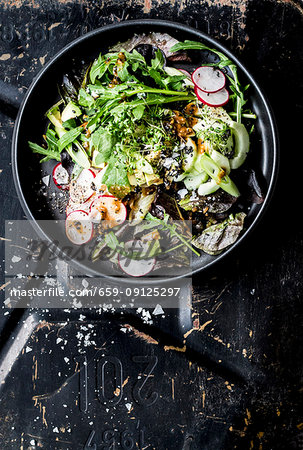 A green salad with radishes, spring onion and tahini