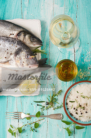 An arrangement of gilt-head bream, white wine and salt