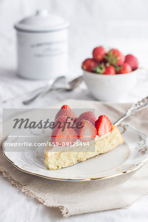 A slice of strawberry cake topped with set custard