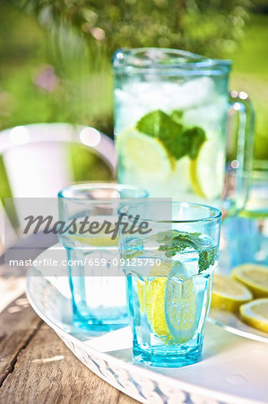 Water with lemon and mint on a garden table