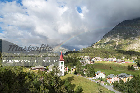 Rainbow over Chiesa Bianca and the village of Maloja, Bregaglia Valley, Engadine, Canton of Graubunden (Grisons), Switzerland, Europe