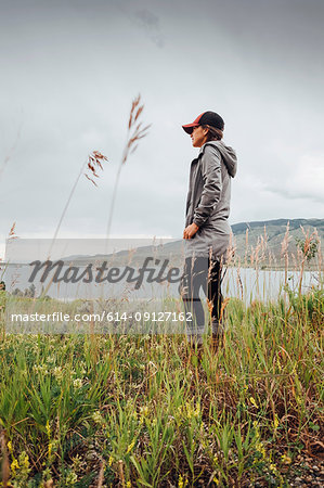 Young woman standing near Dillon Reservoir, looking at view,, Silverthorne, Colorado, USA