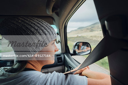 Young woman sitting in car, looking at view out of car window, Silverthorne, Colorado, USA
