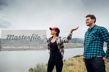 Couple walking near Dillon Reservoir, young woman's arms raised, Silverthorne, Colorado, USA