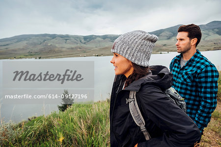 Couple hiking, standing beside Dillon Reservoir, looking at view, Silverthorne, Colorado, USA