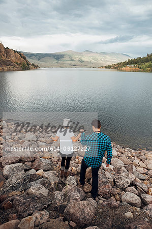 Couple walking on rocks beside Dillon Reservoir, elevated view, Silverthorne, Colorado, USA
