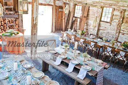 Place settings with table decorations in barn