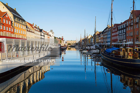 Moored restaurant boat and colourful 17th century town houses on Nyhavn canal, Copenhagen, Denmark