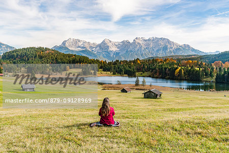 Woman sitting and staring at Gerold lake and Karwendel Alps. Krün, Upper Bavaria, Bavaria, Germany.