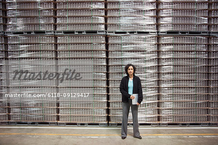 Portrait of an African American female manager in a storage warehouse for pallets of flavoured bottled water.