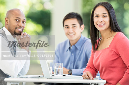 Mixed race team of business people at a table in a business centre.