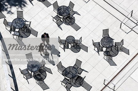 View from above of two business people meeting outside in an open air cafe area.