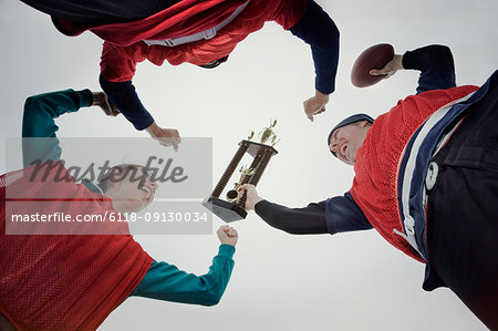 Team members celebrating a victory and a trophy in an outdoor sporting event in the winter.