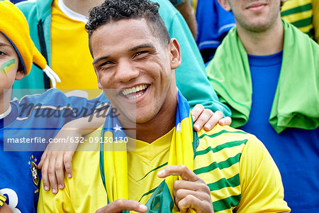 Brazilian football fan smiling cheerfully at match