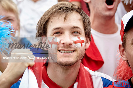 British football fan smiling at match, portrait