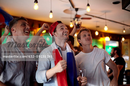 French football fans watching match in bar