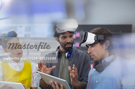 Computer programmers with digital tablet programming virtual reality simulators
