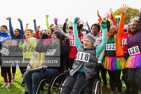 Enthusiastic crowd cheering at charity race in park