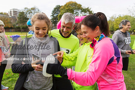 Family runners with smart phone at charity run in park