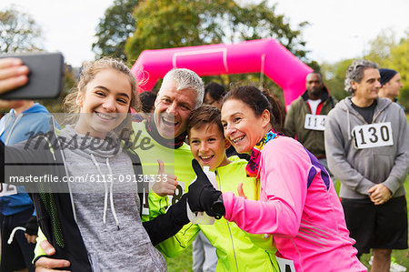 Enthusiastic family runners taking selfie at charity race