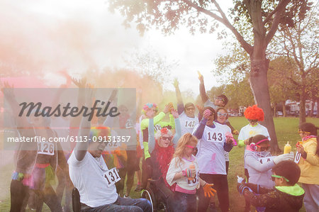 Playful runners throwing holi powder at charity run in park