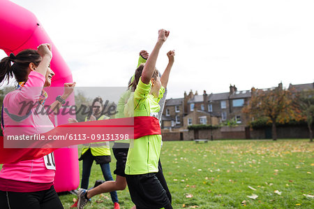 Enthusiastic family crossing finish line at charity run in park