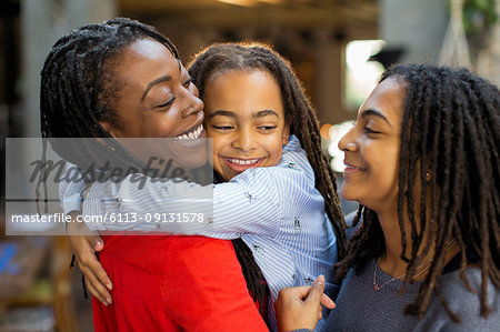 Affectionate mother and daughters hugging