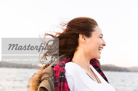 Smiling, carefree woman at windy lakeside