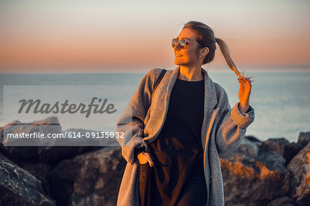 Portrait of woman wearing sunglasses and winter coat looking away smiling, Odessa, Odeska Oblast, Ukraine, Eastern Europe
