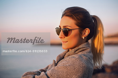 Portrait of woman with ponytail wearing sunglasses looking away smiling, Odessa, Odeska Oblast, Ukraine, Eastern Europe