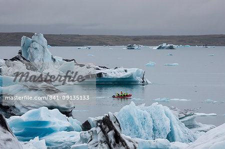 Boat amongst calved ice from the Breidamerkurjokull glacier in Jokulsarlon glacial lagoon, Iceland, Polar Regions