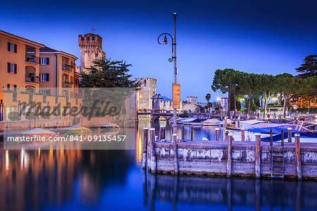 View of Scaliger Castle and boats in harbour at dusk, Sirmione, Lake Garda, Lombardy, Italian Lakes, Italy, Europe