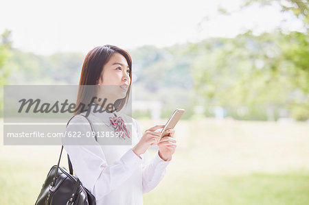 Cute Japanese high school student in a city park