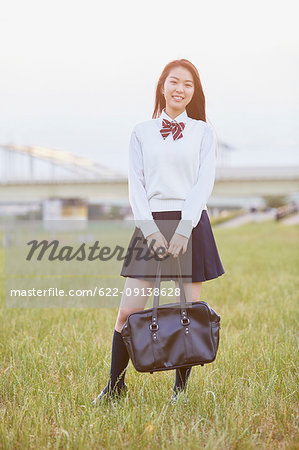 Cute Japanese high school student in a city park